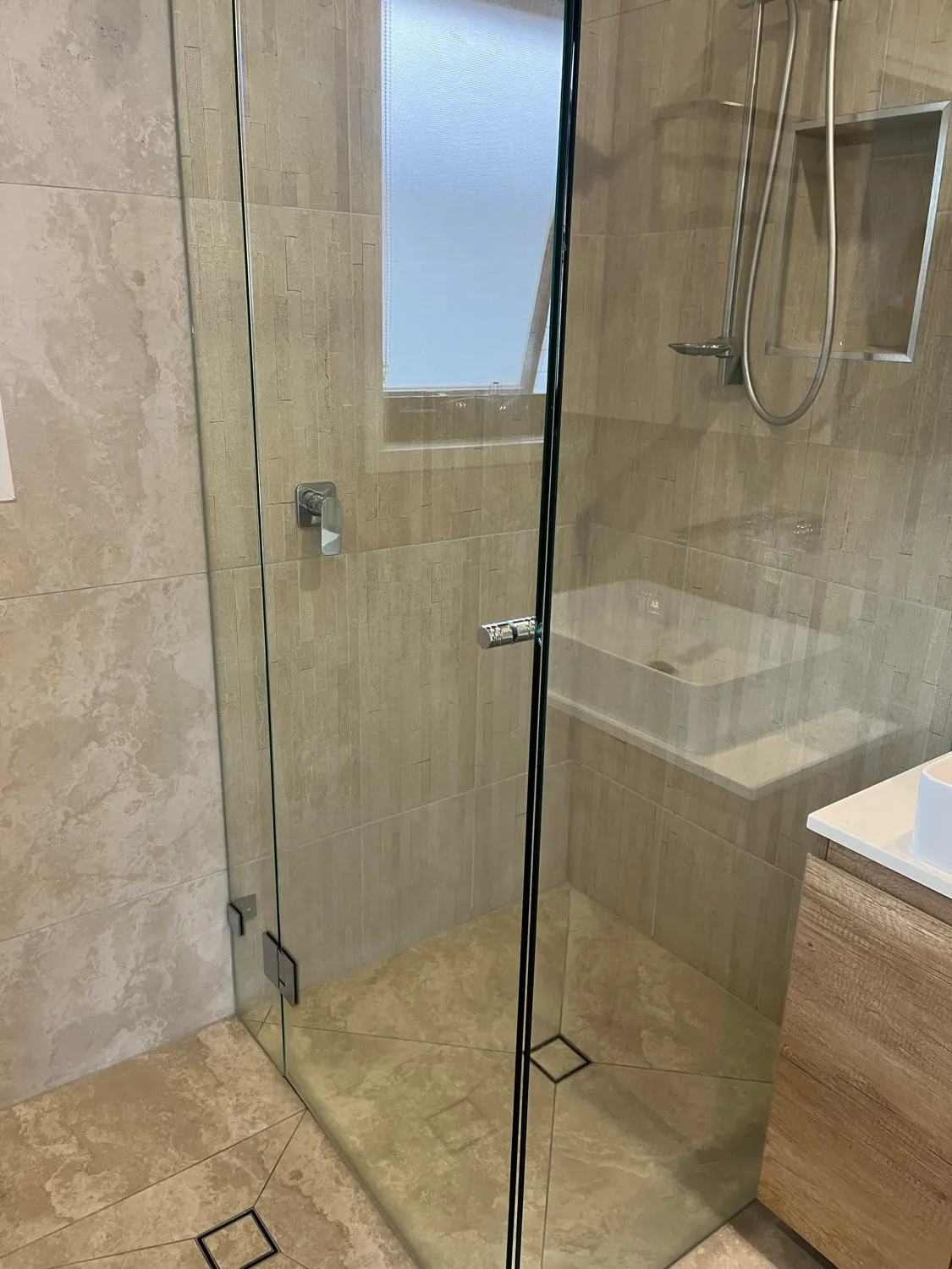 Frameless shower glass with mineral deposits after cleaning